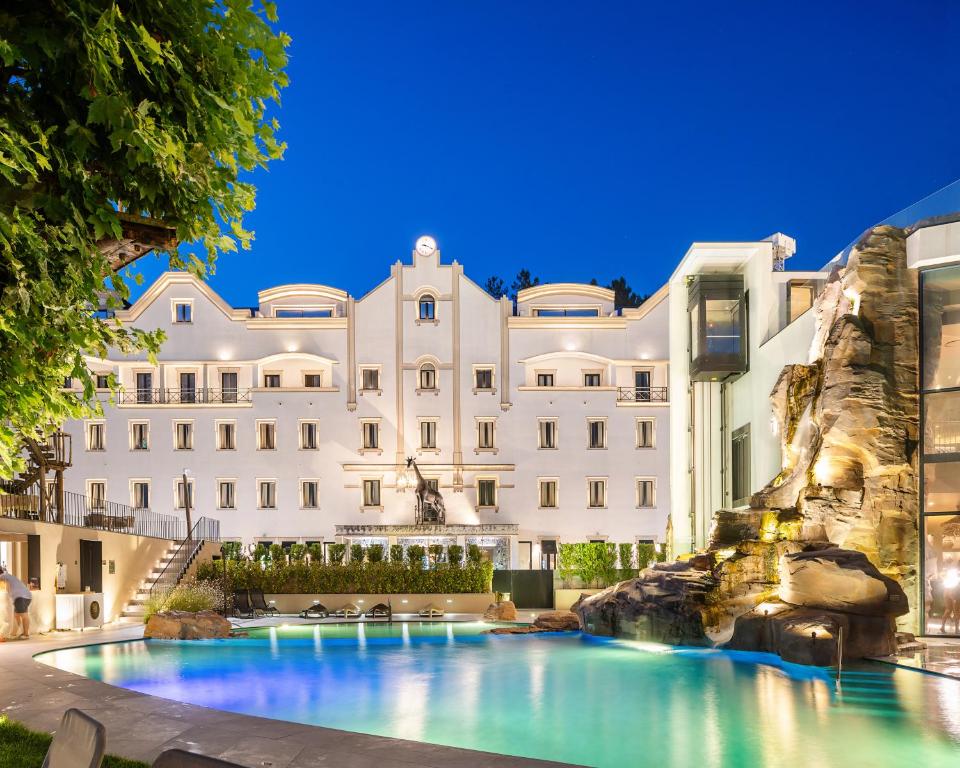 a large building with a swimming pool in front of it at Grande Hotel Thermas Nature & SPA in Termas de Sao Pedro do Sul