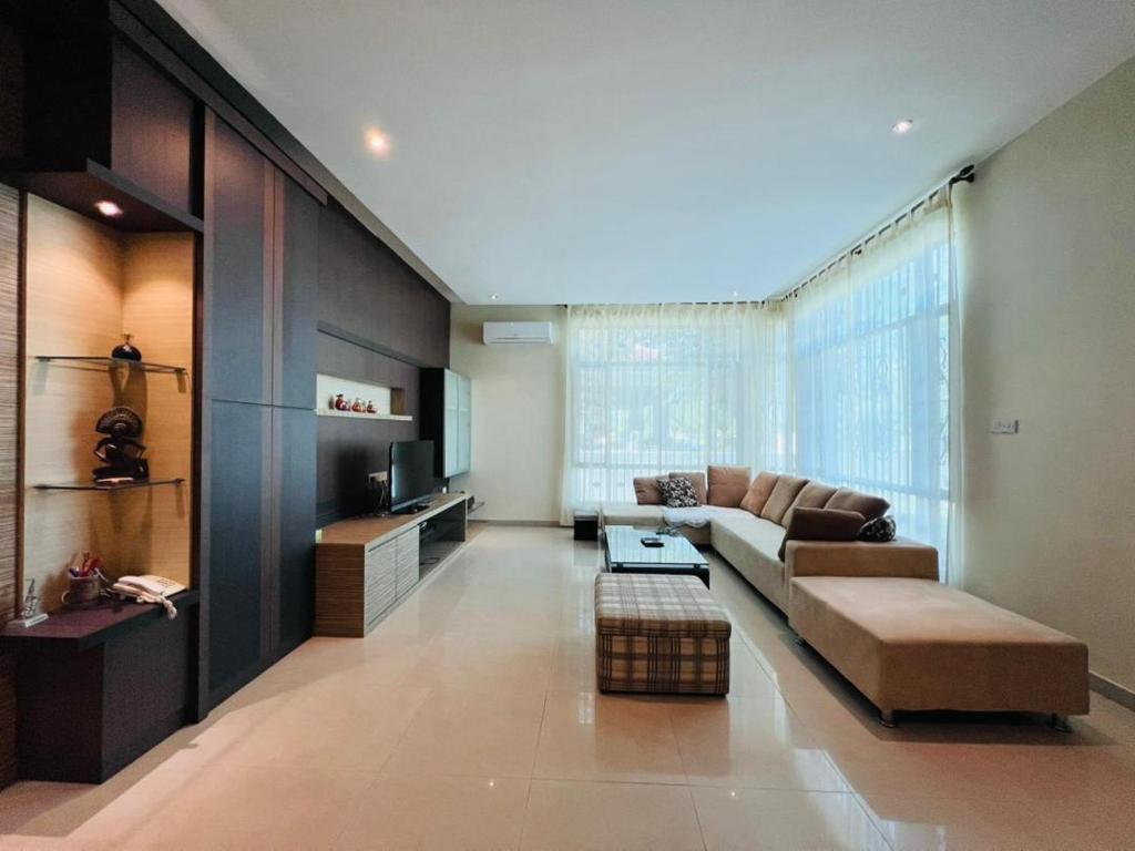 a large living room with a couch and a tv at Exclusive Bungalow Private & Peaceful in Miri Ocean Park 5BR in Miri