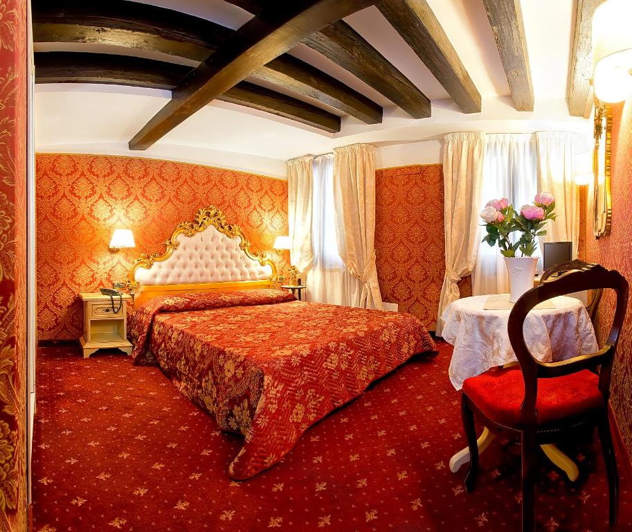 a bedroom with a large bed and a red carpet at Ca' Della Loggia in Venice
