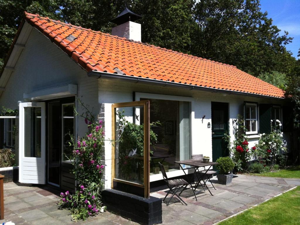 a small white cottage with an orange roof at Beautiful holiday home Zeeroos in Zeeland in Dishoek