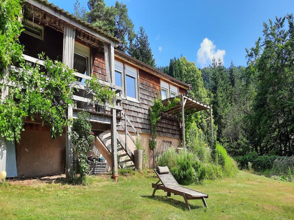 a bench sitting in the grass in front of a house at Chalet in Raon-l'Étape near Lake in Raon-lʼÉtape