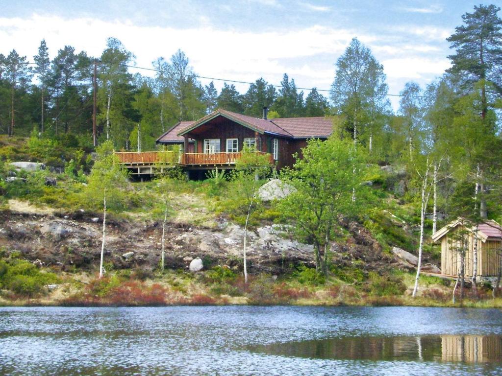 a house on a hill next to a body of water at 8 person holiday home in BJELLAND-By Traum in Bjelland