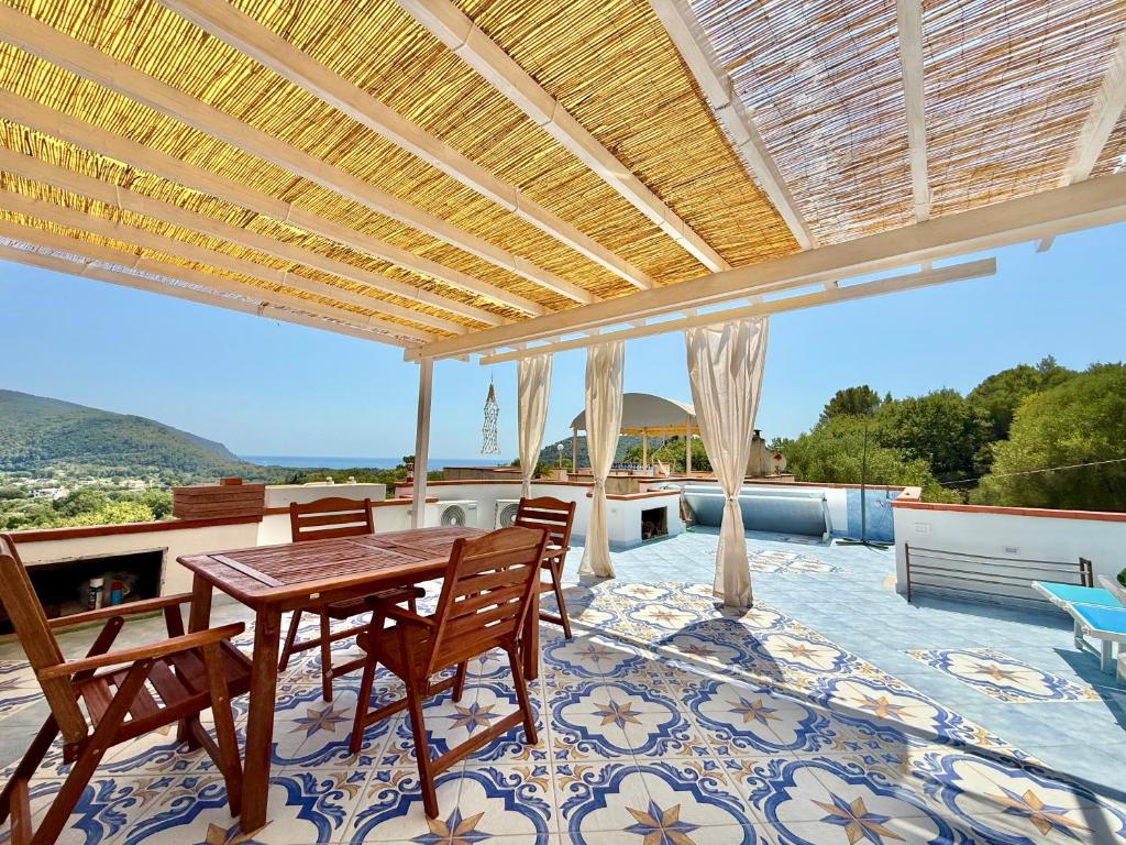 a patio with a wooden table and chairs on a patio at La Maison de Annabella in Palinuro
