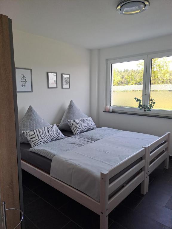 a bedroom with a large bed with a window at FeWo Müller in Simmersfeld