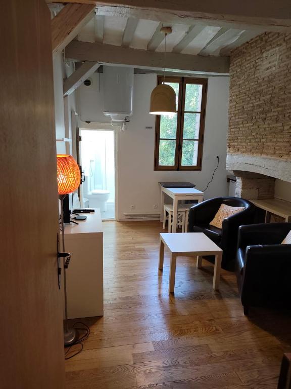 a living room with a couch and a table at Suite Duplex Vientiane - Second Lodge - Hyper Centre Historique Rennes - 2 personnes in Rennes