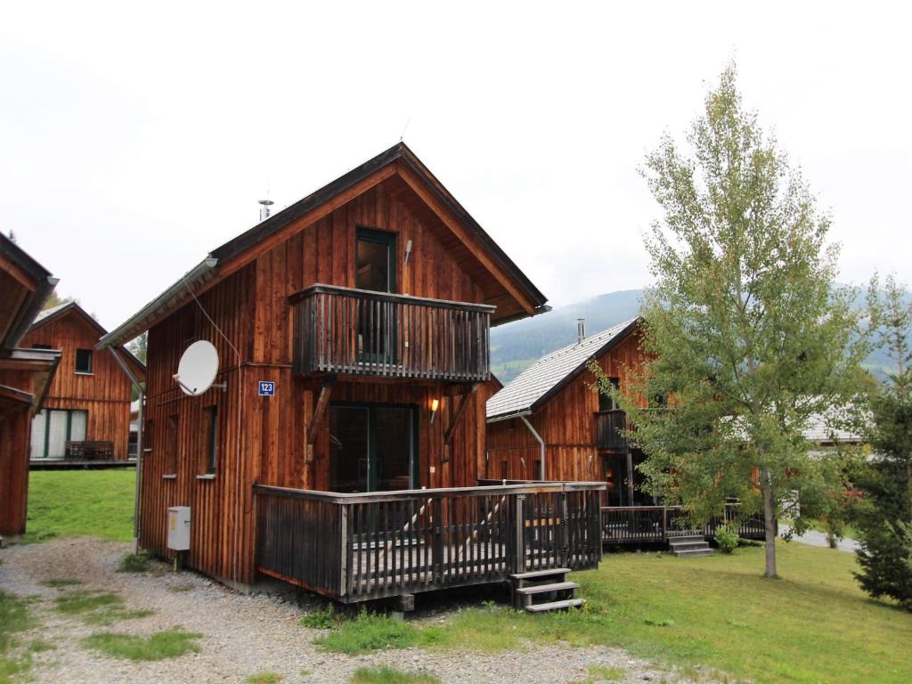 a wooden cabin with a balcony and a tree at Chalet in Stadl an der Mur near Ski Slopes in Stadl an der Mur