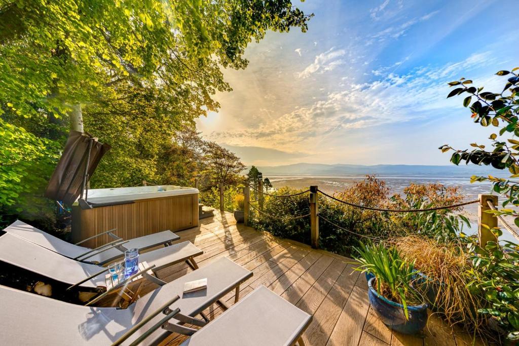 a patio with chairs and a view of the ocean at Ty Mor Wennol in Aberdyfi