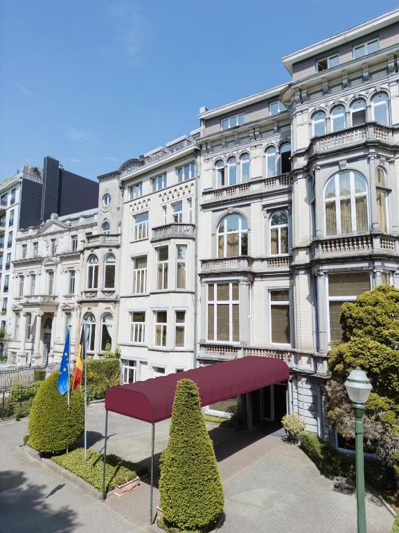 ein weißes Gebäude mit einer roten Markise davor in der Unterkunft Park Hotel Brussels in Brüssel