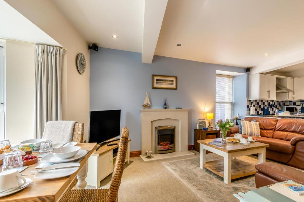a living room with a table and a fireplace at Seacove in Saundersfoot