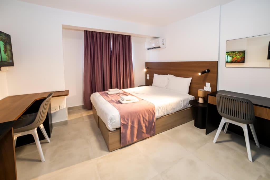 a hotel room with a bed and a desk at 1-Bedroom Studio with Stunning Sea & Country View in St Paul's Bay