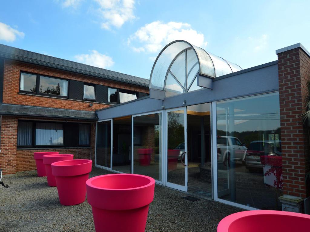 a group of pink stools in front of a building at Trooz Villa with Pool & Sauna in Trooz