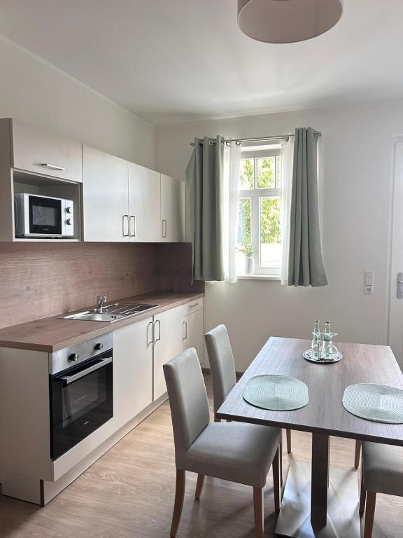 a kitchen with a table and a table and chairs at Brommy Apartments in Brake