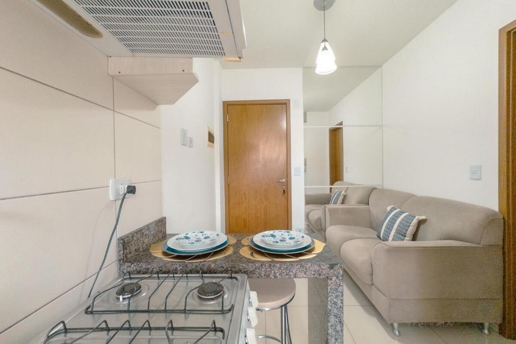 a kitchen and living room with a couch and a table at Veja Este Apê Completo! - PS505 in Maringá