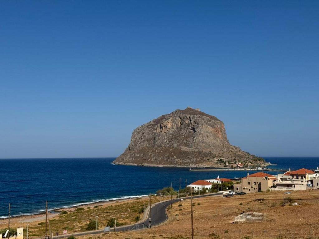 a road in front of a mountain in the ocean at Monemvasia View in Monemvasia