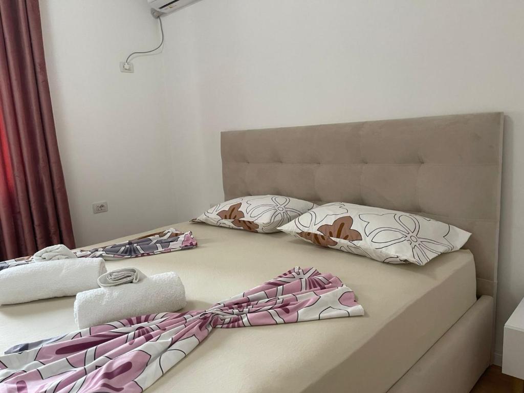 ein Bett mit zwei Kissen und Handtüchern darauf in der Unterkunft City & Canyon - Modern Comfort in Çorovodë