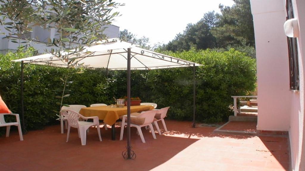 een tafel en stoelen onder een parasol op een patio bij Casa Vacanze Lido del Piacere in Peschici
