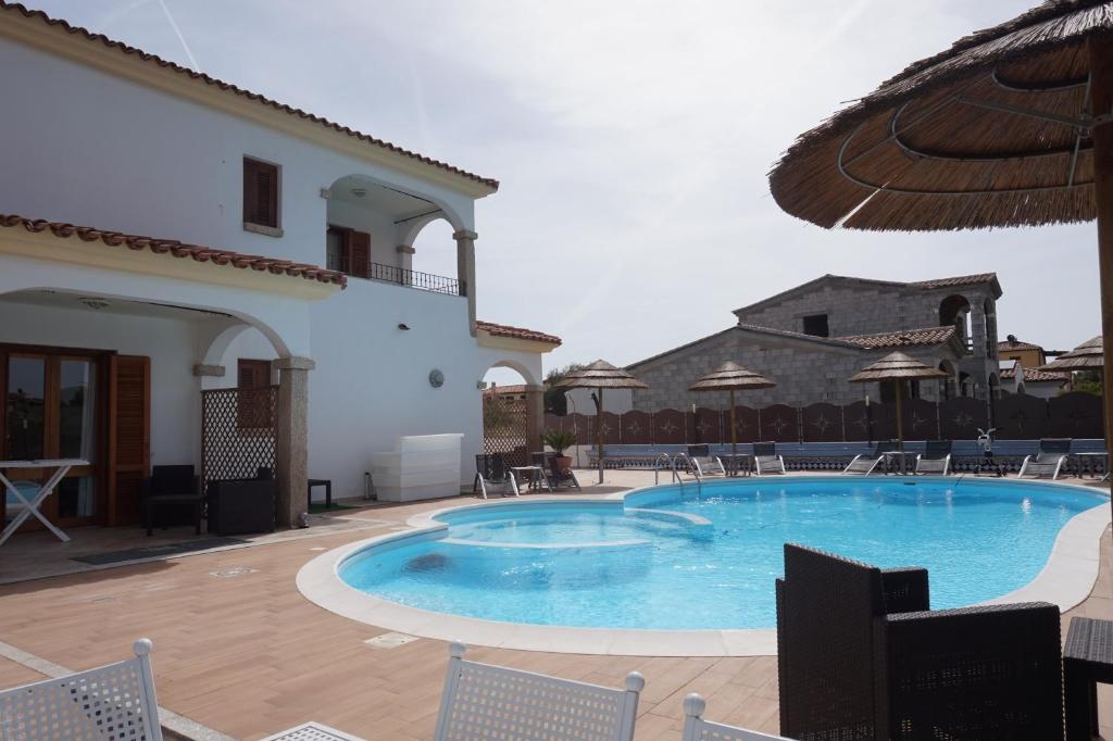 a swimming pool in front of a villa at Hotel Il Platano in San Teodoro