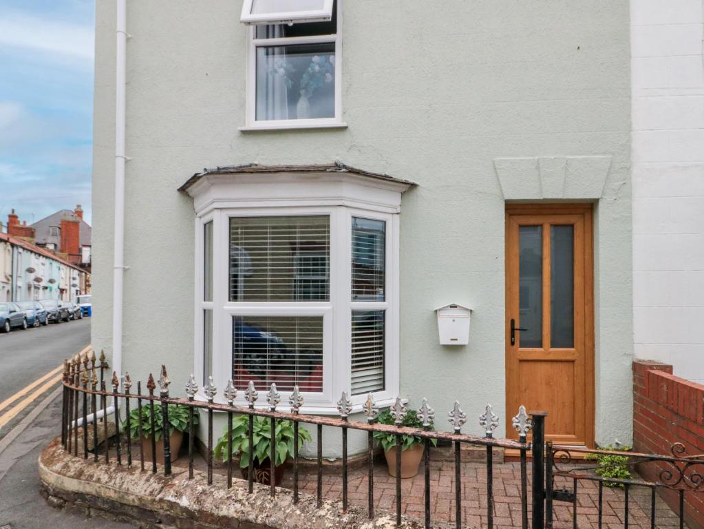 a white house with a window and a fence at Christlow Cottage in Bridlington