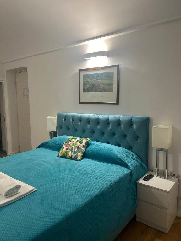 un letto blu con testiera blu in una camera da letto di AH Suite Montecitorio a Roma