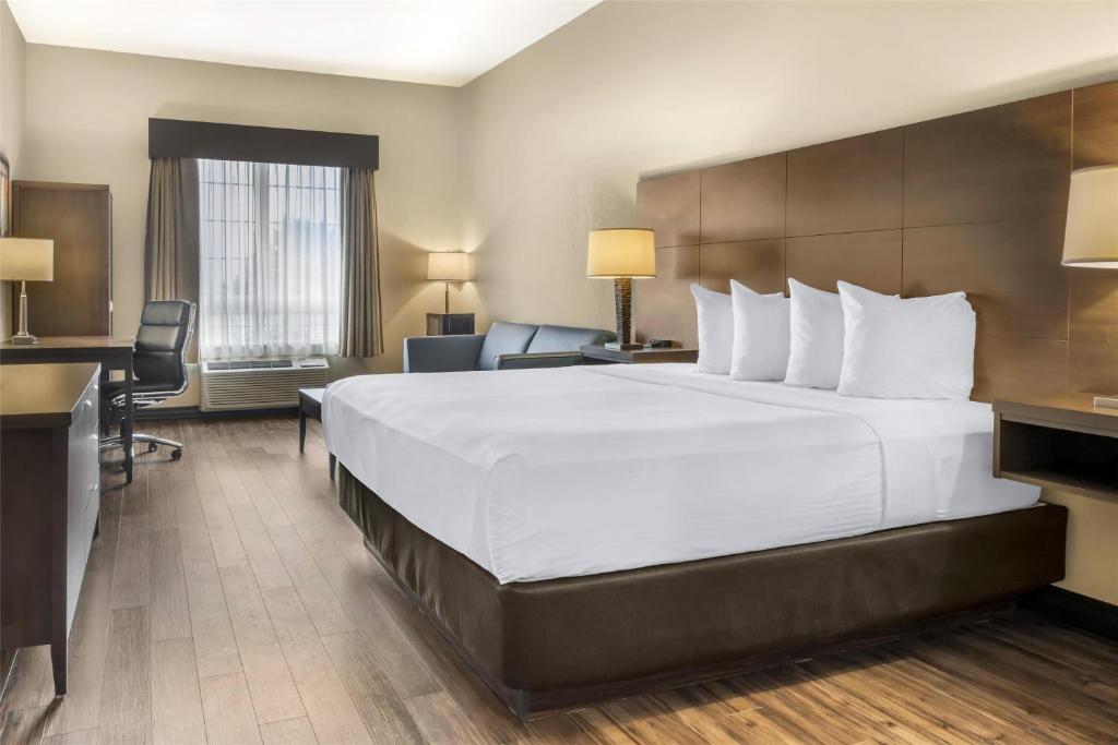 a hotel room with a large bed and a desk at BEST WESTERN PLUS Saint John Hotel & Suites in Saint John