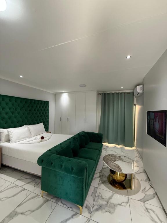 a bedroom with a green couch and a bed at Malrose guesthouse Tours And safaris Windhoek Namibia Airport Shuttle services available in Windhoek
