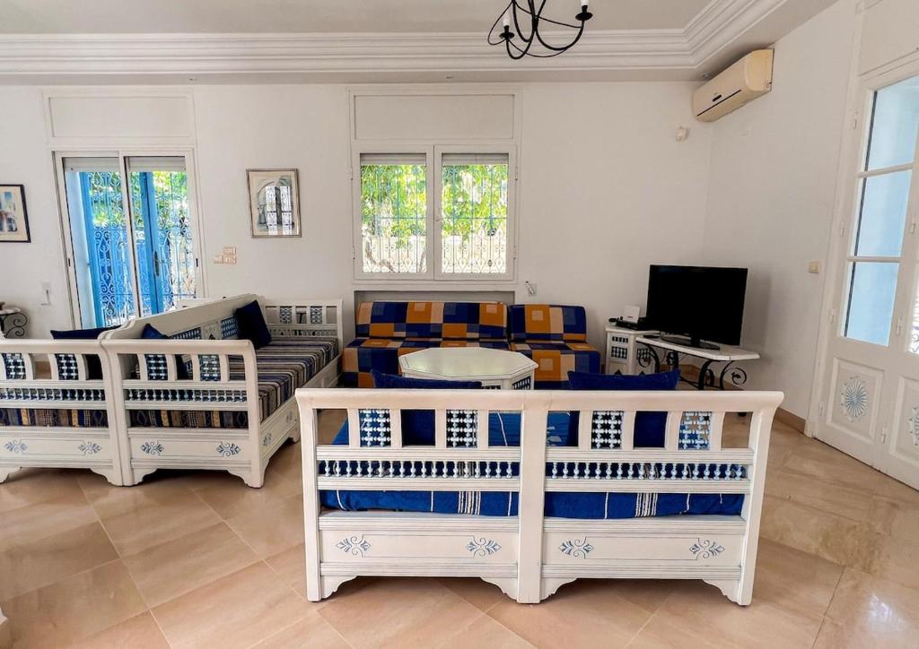 a living room with four chairs and a couch at Sidi Bou Said-style villa with pool in Hammamet