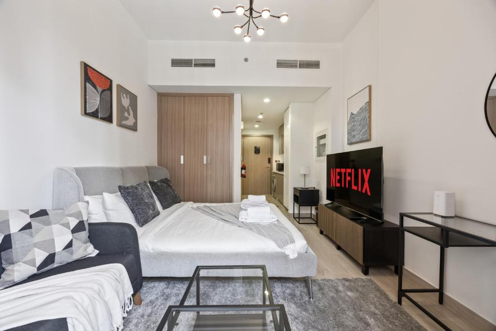 une chambre avec un lit, un canapé et une télévision dans l'établissement Elite Escape - Getaway in Azizi Riviera 26, à Dubaï