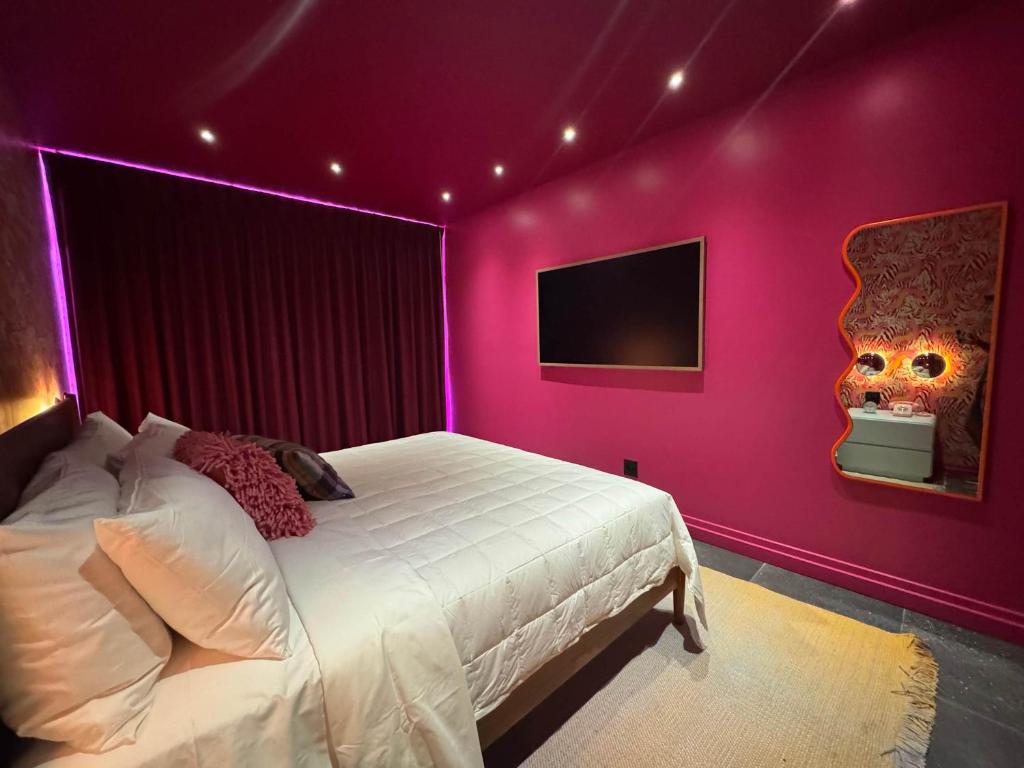 a bedroom with a bed with a purple wall at Hotel Hilo - Room 203 in Louisville