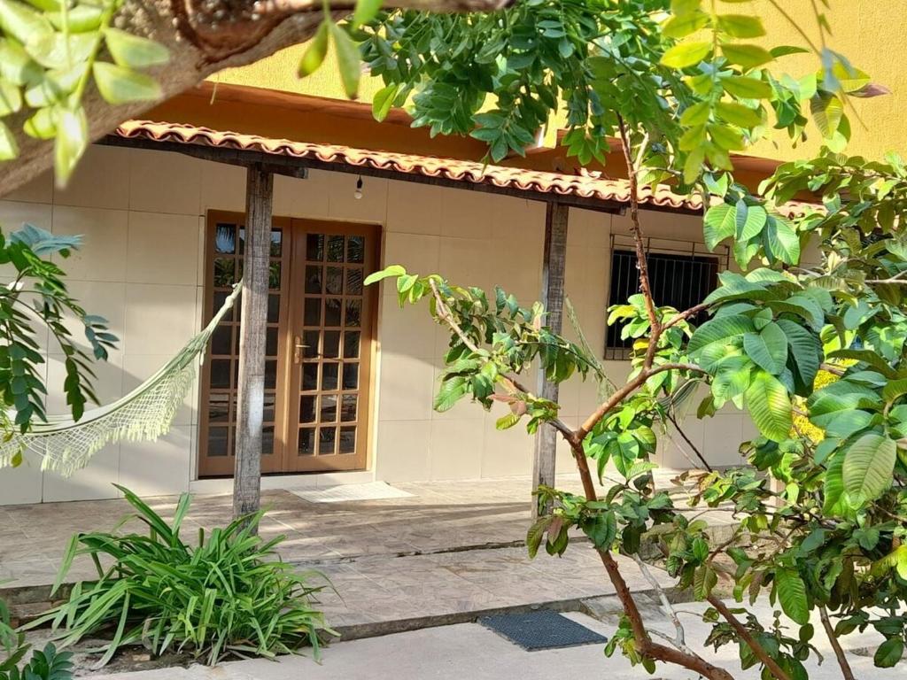 ein Haus mit einer Holzveranda mit einer Tür in der Unterkunft Casa de praia em barra grande in Maragogi