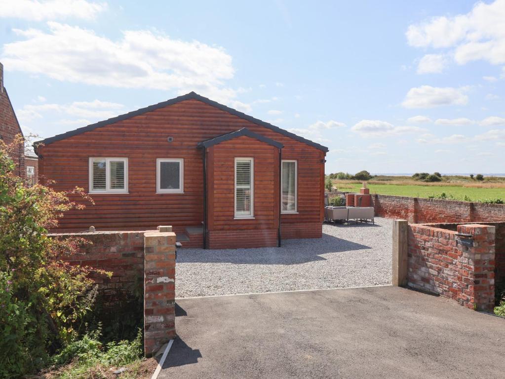 une petite maison en bois avec un mur de briques dans l'établissement Waverley Cottage, à Hull