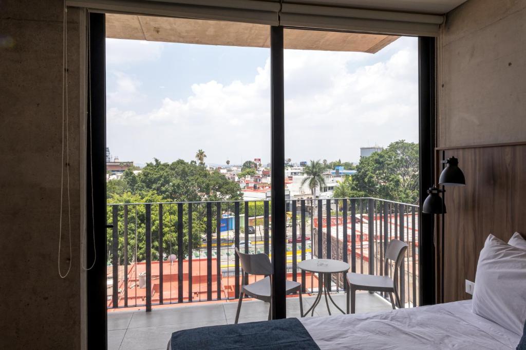 a bedroom with a bed and a balcony with a view at Lapso At Asís in Guadalajara