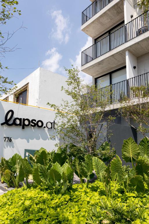 a sign in front of a building with plants at Lapso At Asís in Guadalajara