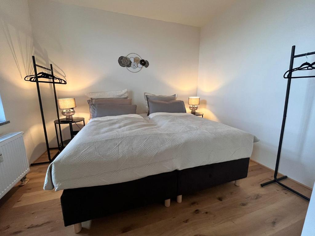 a bedroom with a large bed with two lamps at Royal Haus Chemnitz 3- Balkon nahe Zeisigwald in Chemnitz