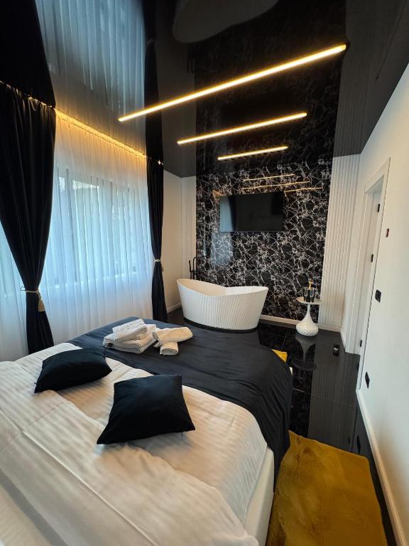 a bedroom with a large bed and a bath tub at HERA Elysium Apartament AFRODITA in Sinaia