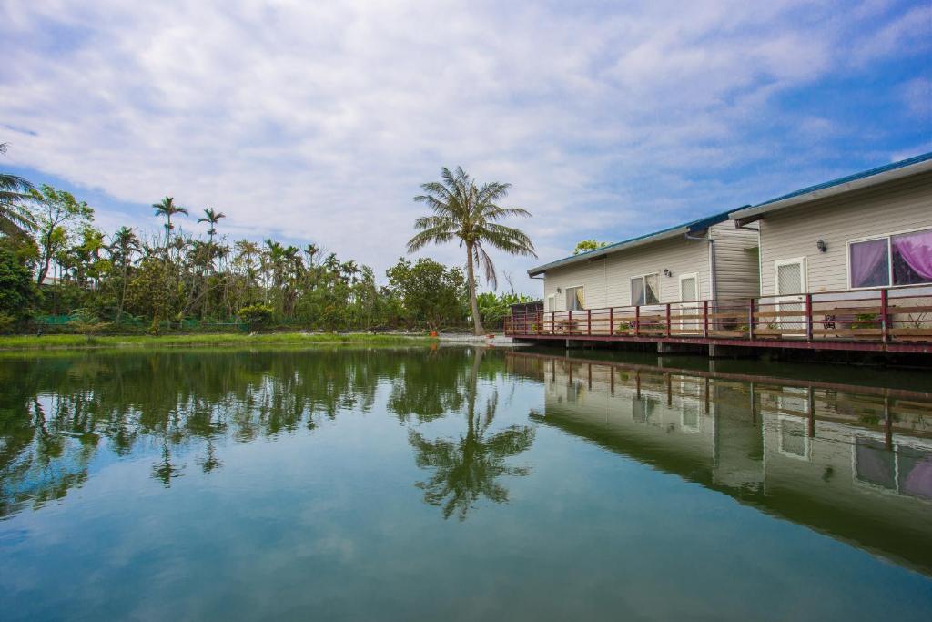 a body of water next to a building and a house at Chenyuan B&B in Ji'an