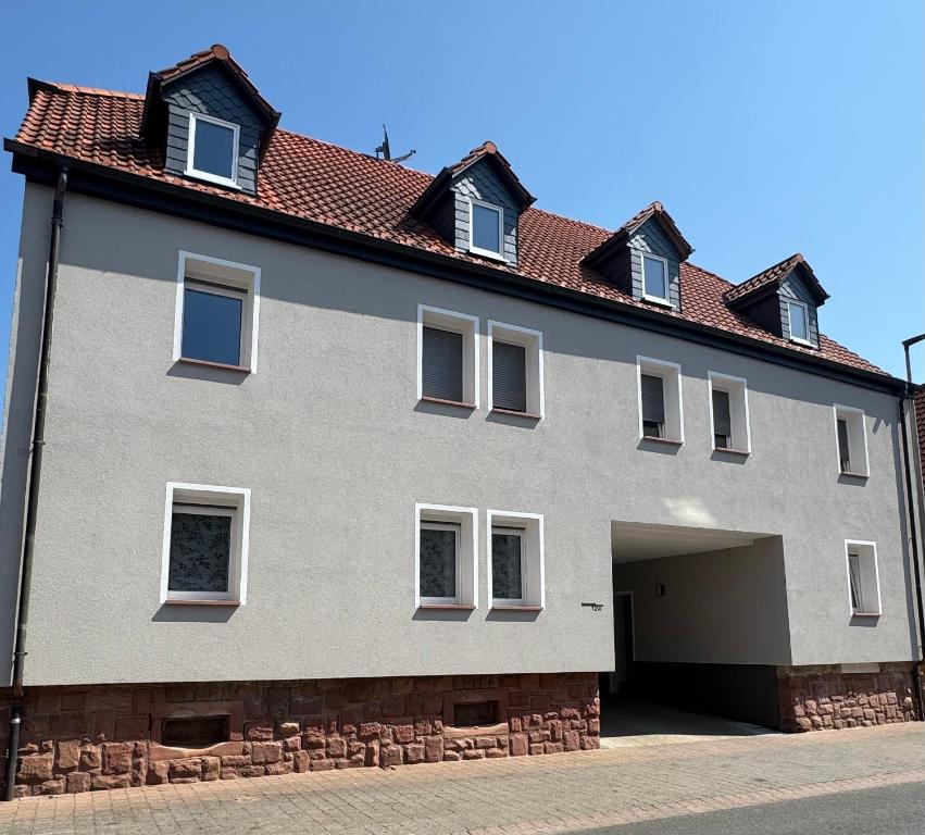 a large gray building with a garage at Ferienwohnung Wasser - Bude in Momlingen