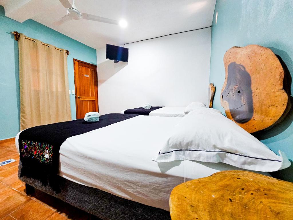 una camera da letto con un grande letto con testiera in legno di Mayas Blue Bacalar a Bacalar