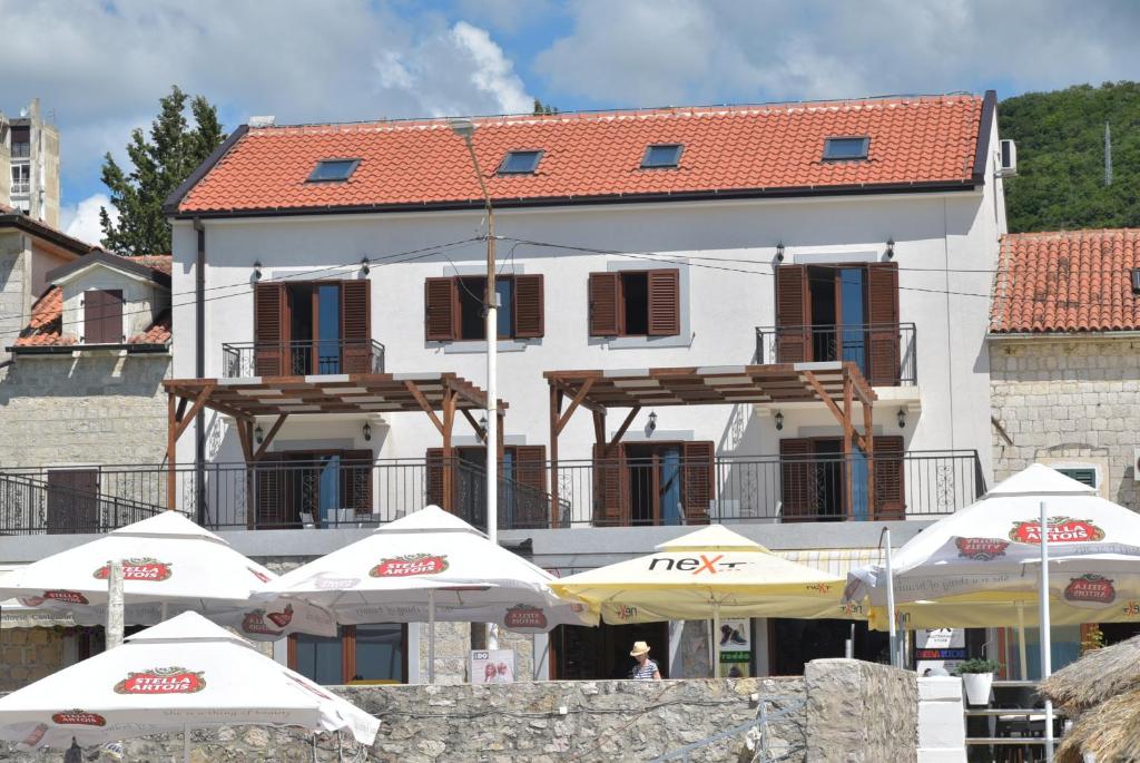 un grupo de sombrillas frente a un edificio en Apartmani Centar Igalo, en Herceg-Novi