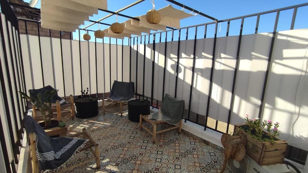 Maison en exclusivité 2 chambre Place Jemma El Fna في مراكش: بلكونه فيها كرسيين وسياج