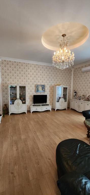 Una gran sala de estar con una lámpara de araña y una sala de estar con un sofá. en Gust house, en Kutaisi