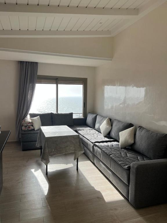 a living room with a couch and a table at Résidence 7 vagues in Oualidia