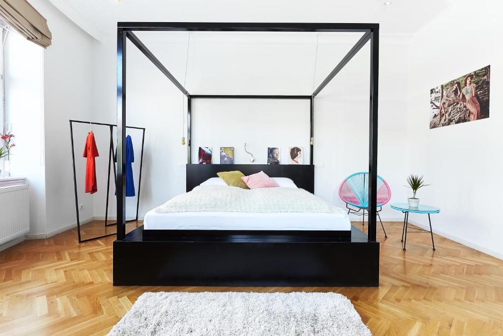 Dormitorio con cama con dosel negra en una habitación en The Magazine Hotel & Apartments, en Budapest