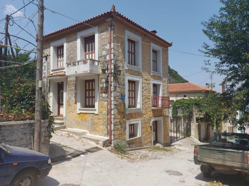 an old stone house with a car parked in front of it at Agiasos Stavri Traditional Stone House in Agiásos