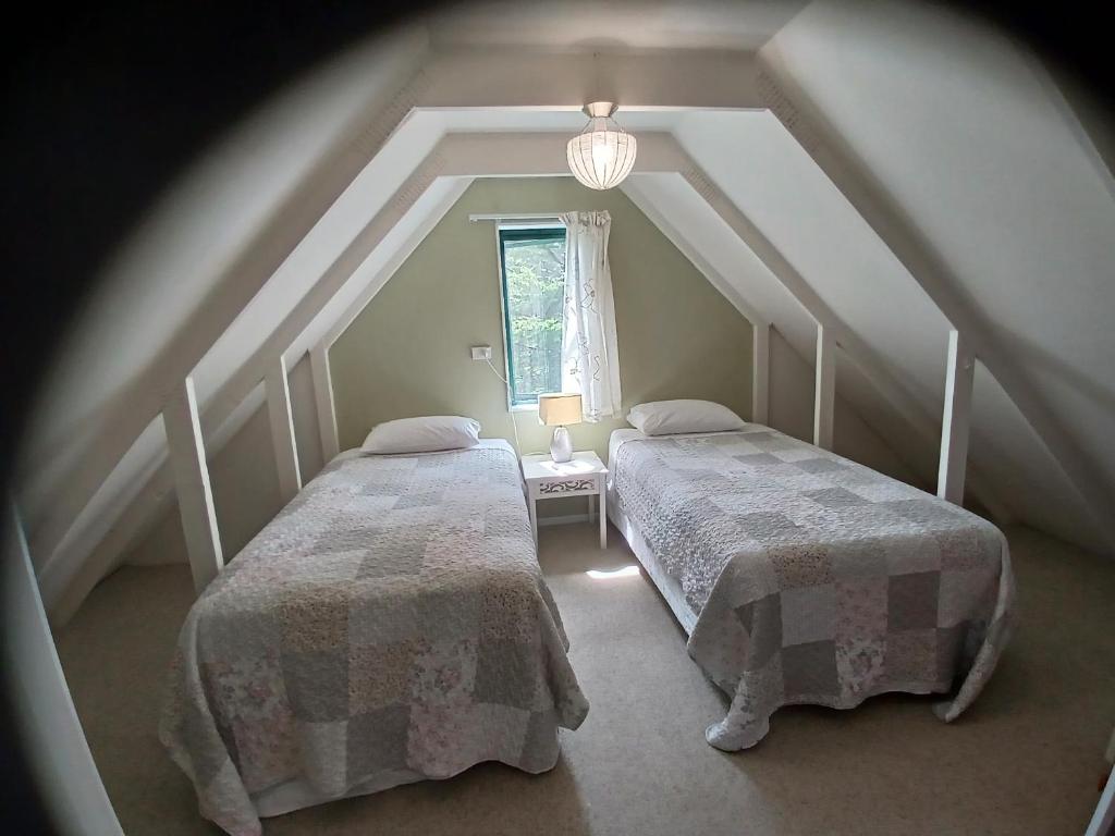 Habitación en el ático con 2 camas y ventana en Waimate Cottage - Waimate North, en Waimate North