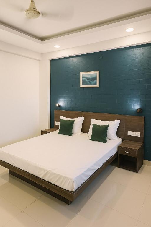 インドールにあるHomezype Homes Luxury Stayの青い壁の大きなベッドのある寝室