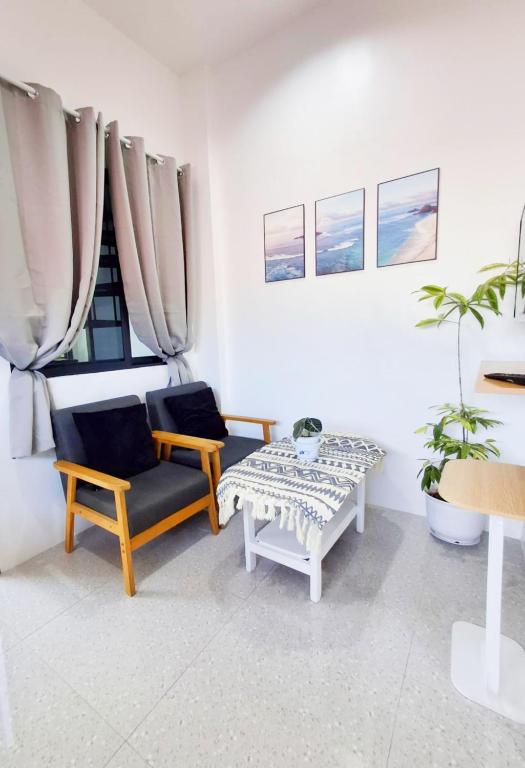 a living room with two chairs and a table at Apartelle 386 in Dipolog