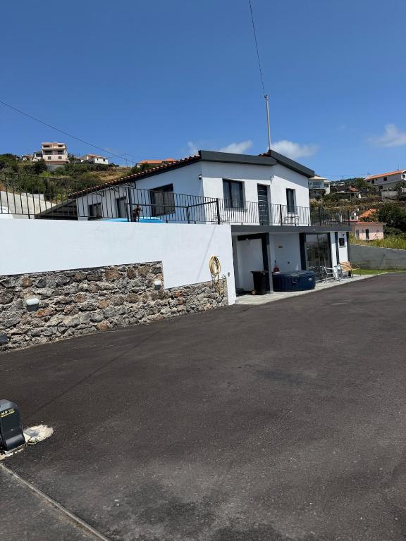 a white building with a stone wall and a street at Casa Camacho - Santa Cruz in Santa Cruz