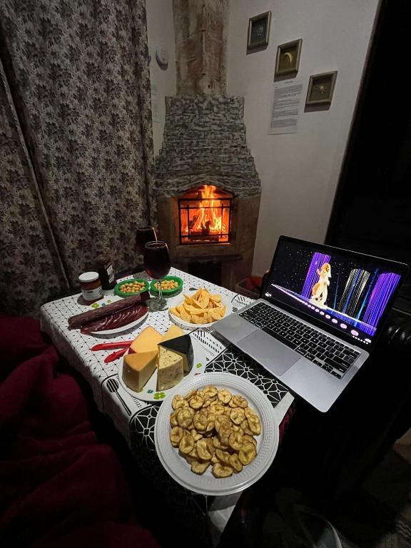 a table with a laptop and a plate of food at AP Temporada Monte Verde in Monte Verde