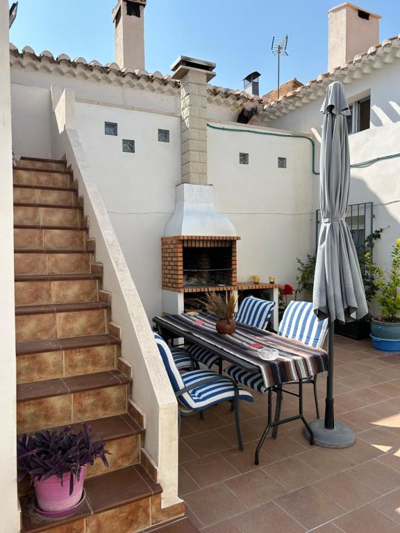 un patio con 2 sedie, un tavolo e un camino di Casa Rural Villa María a Liétor