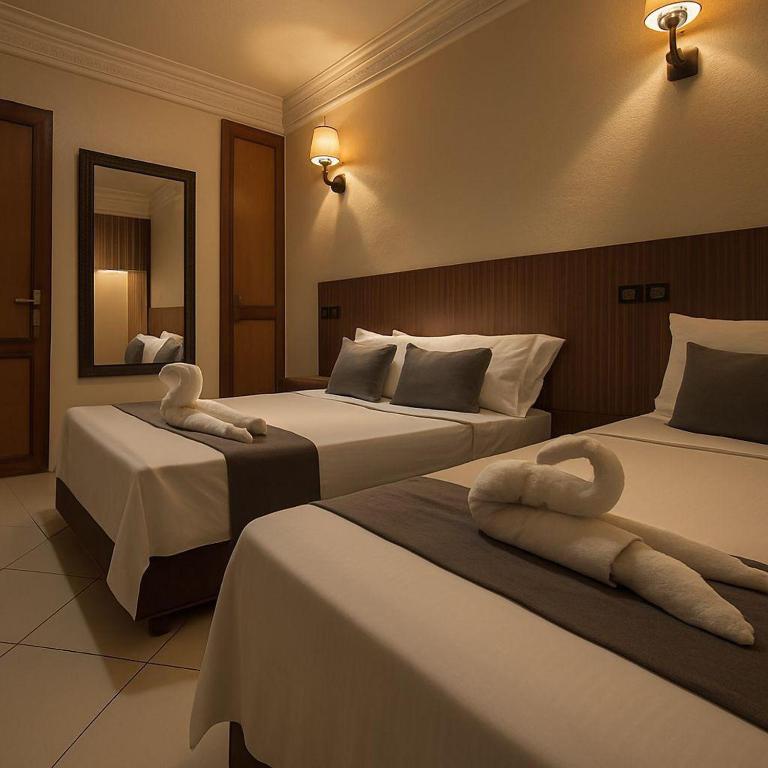 a hotel room with two beds with towels on them at Apparts-hôtel ISNI in Agadir